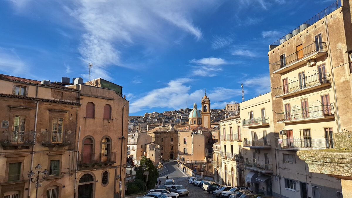Panoramic view over the historic centre of Caltagirone, with rooftops, church domes and towers on the hill
