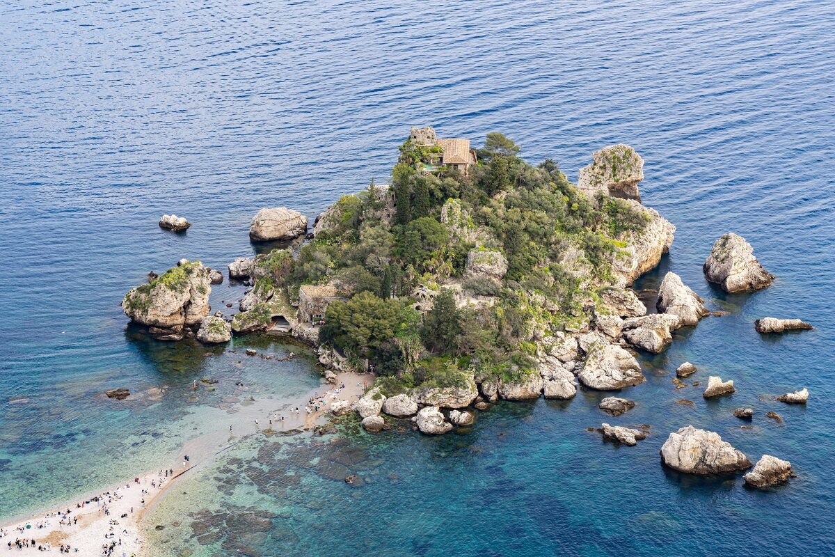 Isola Bella, a small wooded island off Taormina, with a pebble beach and clear blue water in the cove