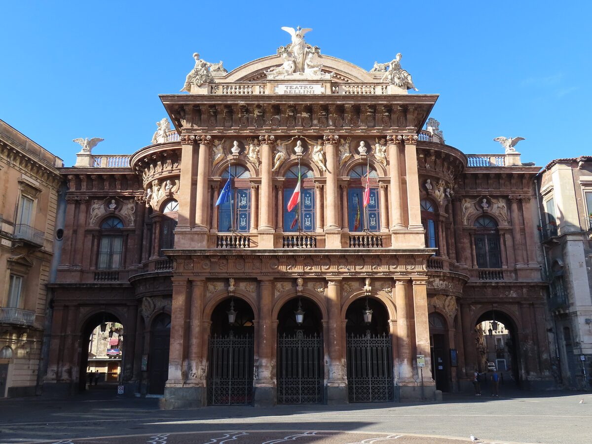 Facade of the Teatro Massimo Vincenzo Bellini in Catania, a long front with arches, columns and sculpted balconies