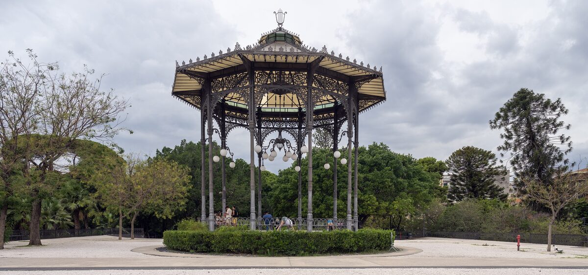 Iron bandstand with a pointed roof in the shade of trees in Villa Bellini, the park of Catania