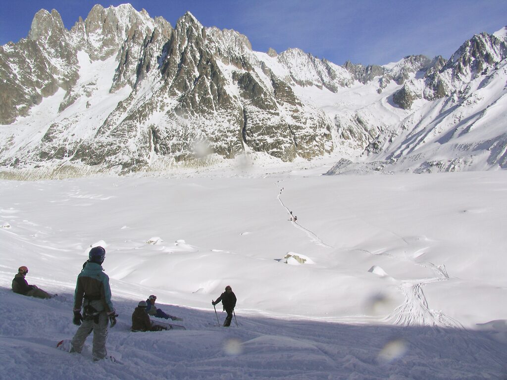 Skiers crossing the snowfield of the Vallée Blanche with jagged peaks rising behind