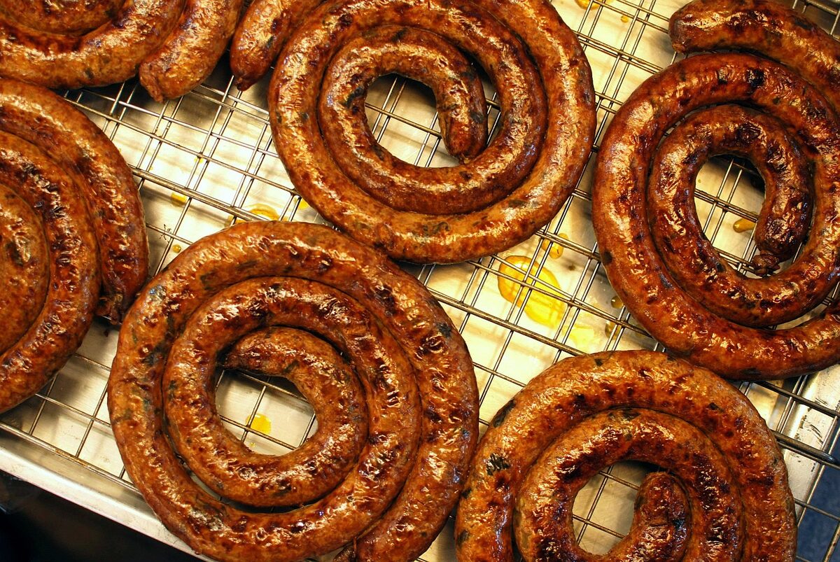 Coiled Chiang Mai sausages grilling on a metal rack