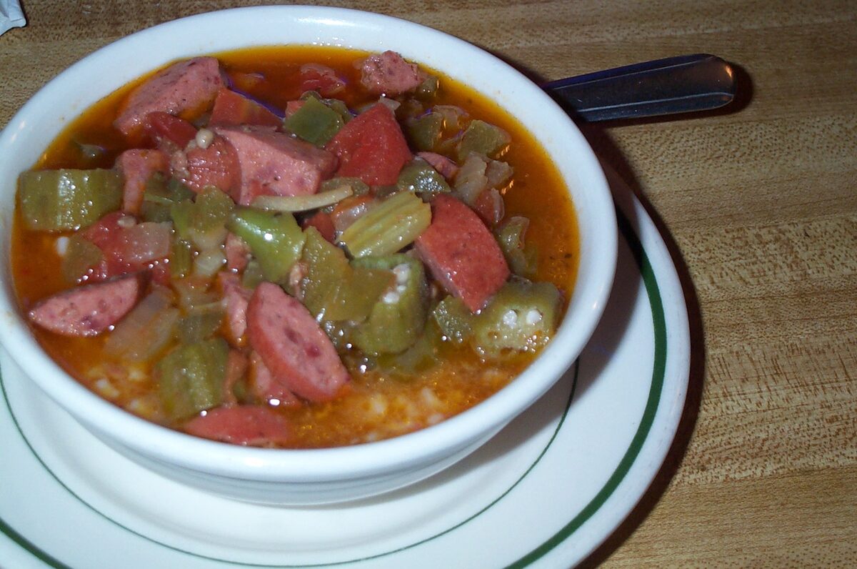 A bowl of gumbo with sausage slices, okra and rice