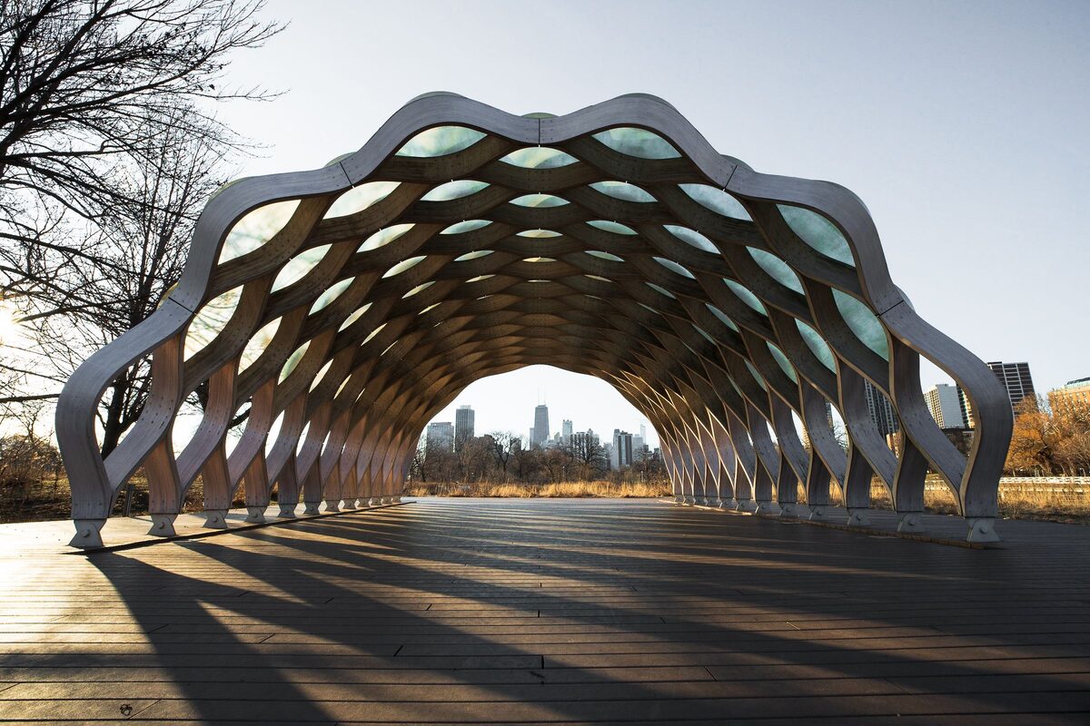 The curved timber pavilion of the Nature Boardwalk at Lincoln Park Zoo, with the skyline in the distance