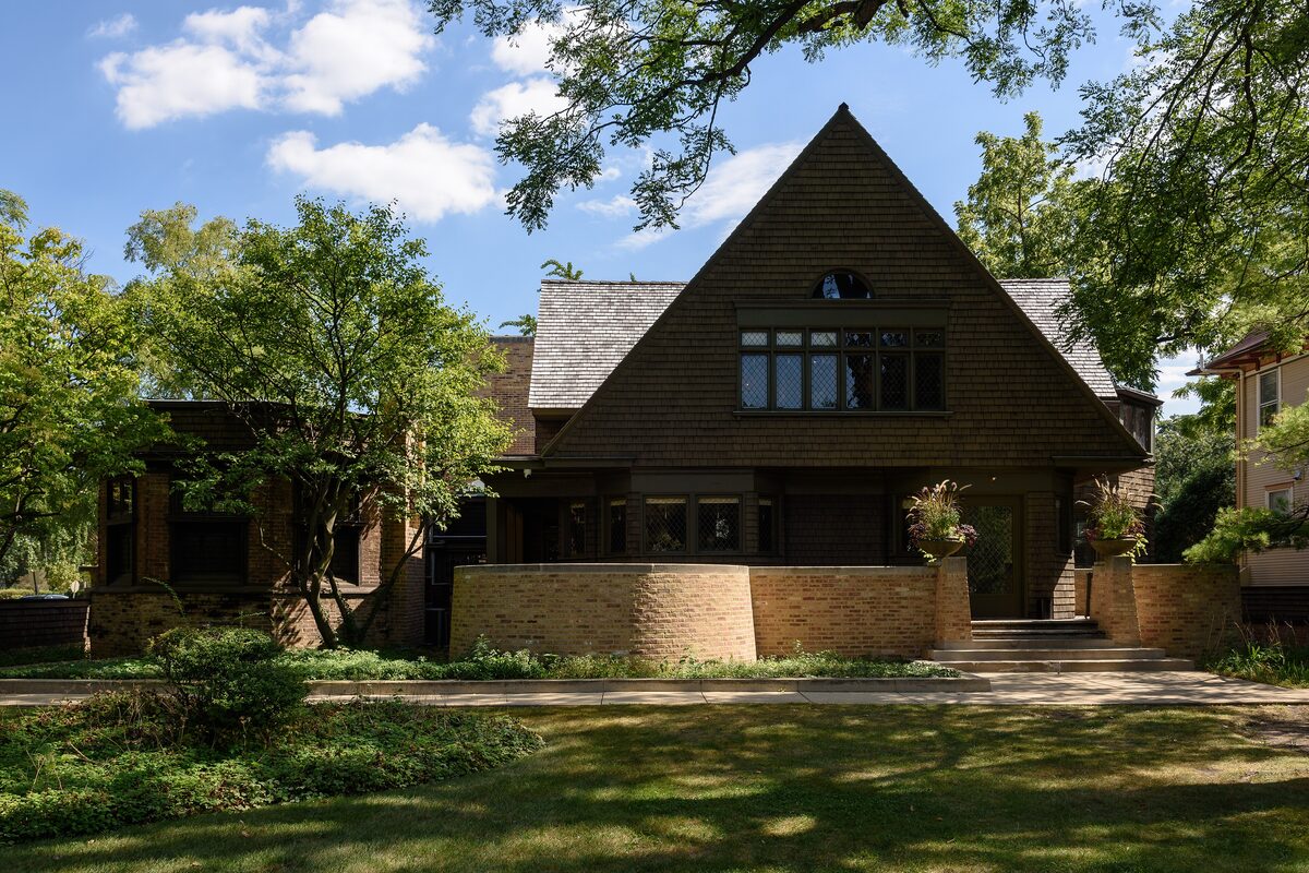 The shingled gable of Frank Lloyd Wright's Home and Studio in Oak Park, behind a lawn and trees