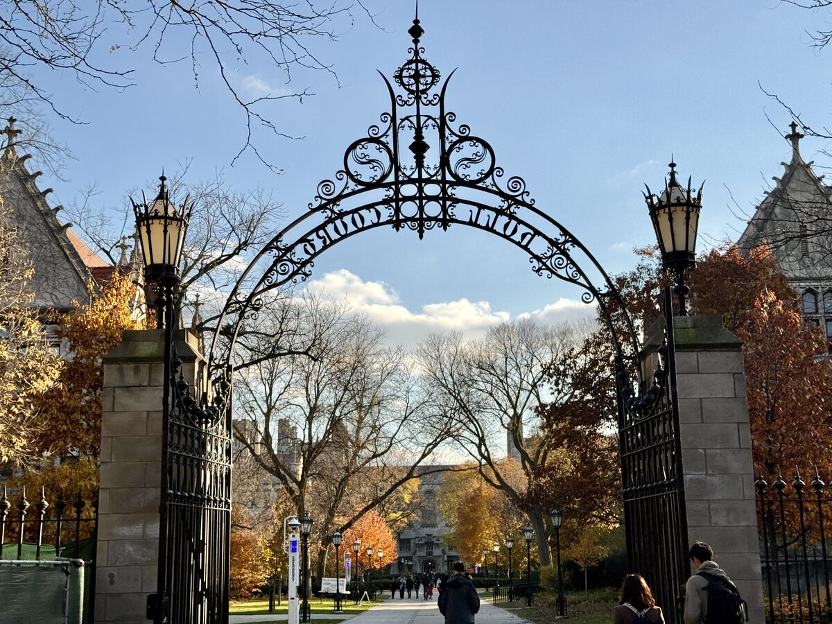 The wrought-iron Hull Court Gate on the University of Chicago campus, with autumn trees behind