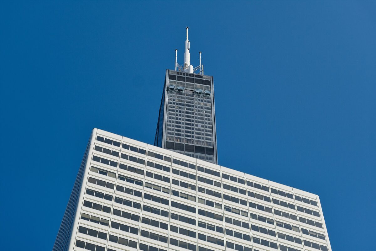 The top of the Willis Tower and its antennas against a deep blue sky