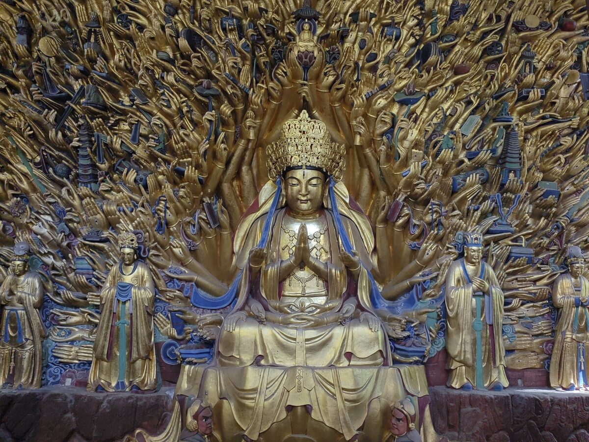 The gilded Thousand-Hand Guanyin at Baodingshan, with hundreds of carved hands fanned out around the central figure