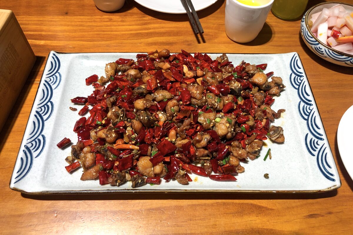 A platter of laziji, small pieces of fried chicken buried in dried red chilies