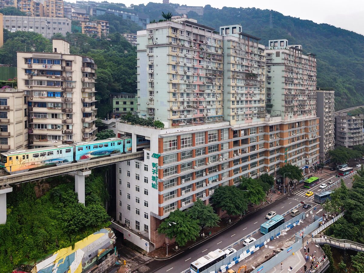 A monorail train running through the middle of a residential tower at Liziba, above a busy street