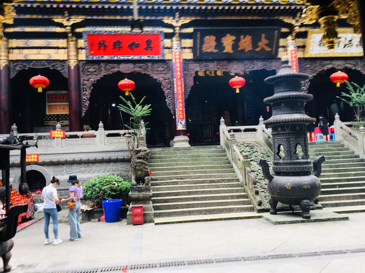 The carved wooden front of the Mahavira Hall at Luohan Temple, with red lanterns and an incense burner on the steps