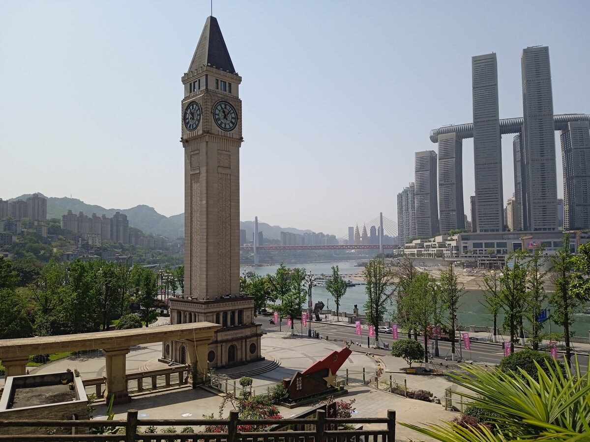 The Nanbin Road clock tower on the Nan'an riverbank, with the Raffles City towers and the river beyond