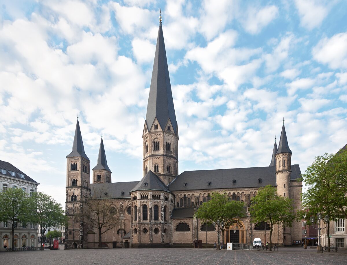 The five towers of the Romanesque Bonn Minster rising behind the cobbled Münsterplatz