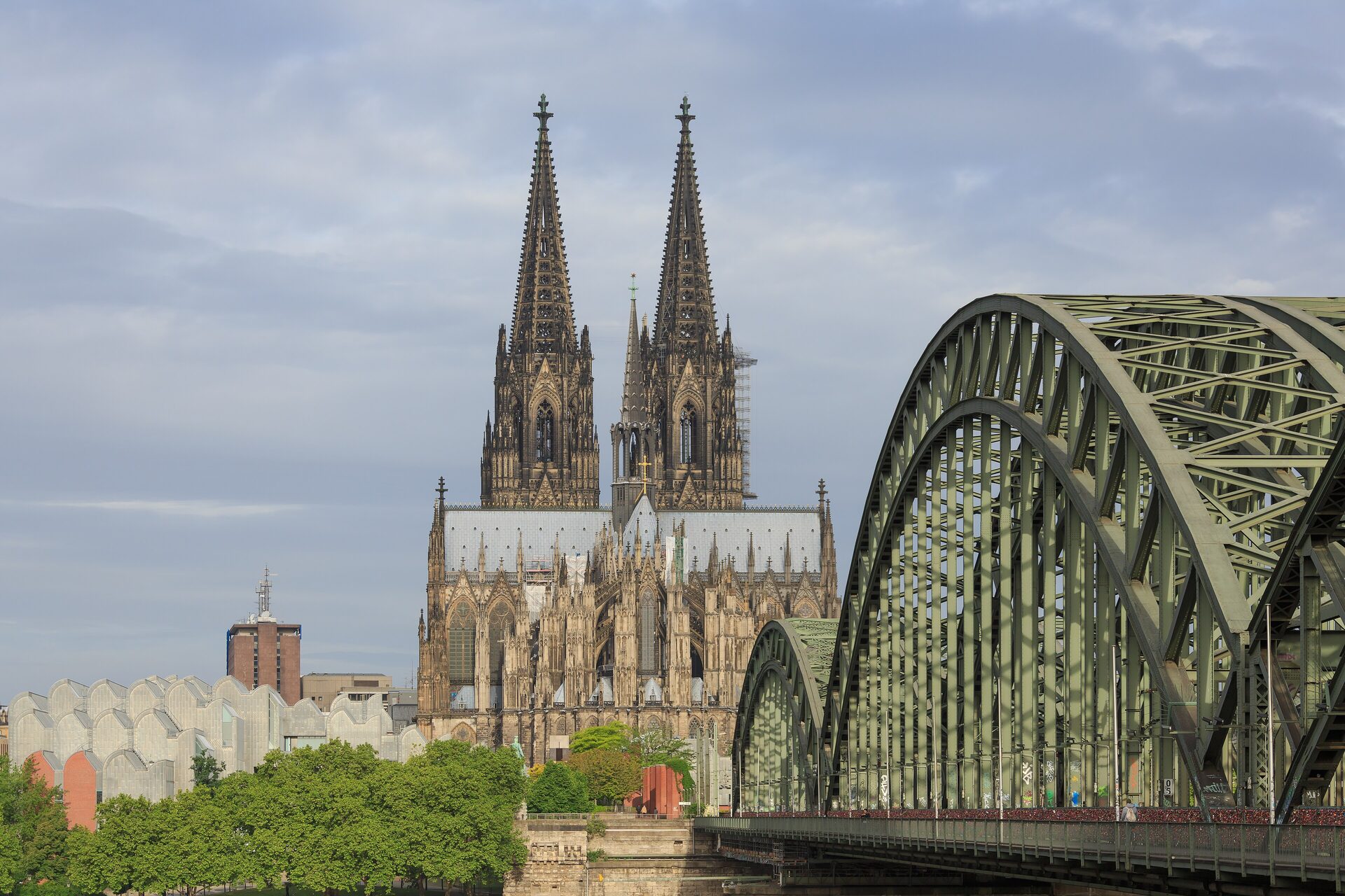 The twin spires of Cologne Cathedral behind the steel arches of the Hohenzollern Bridge