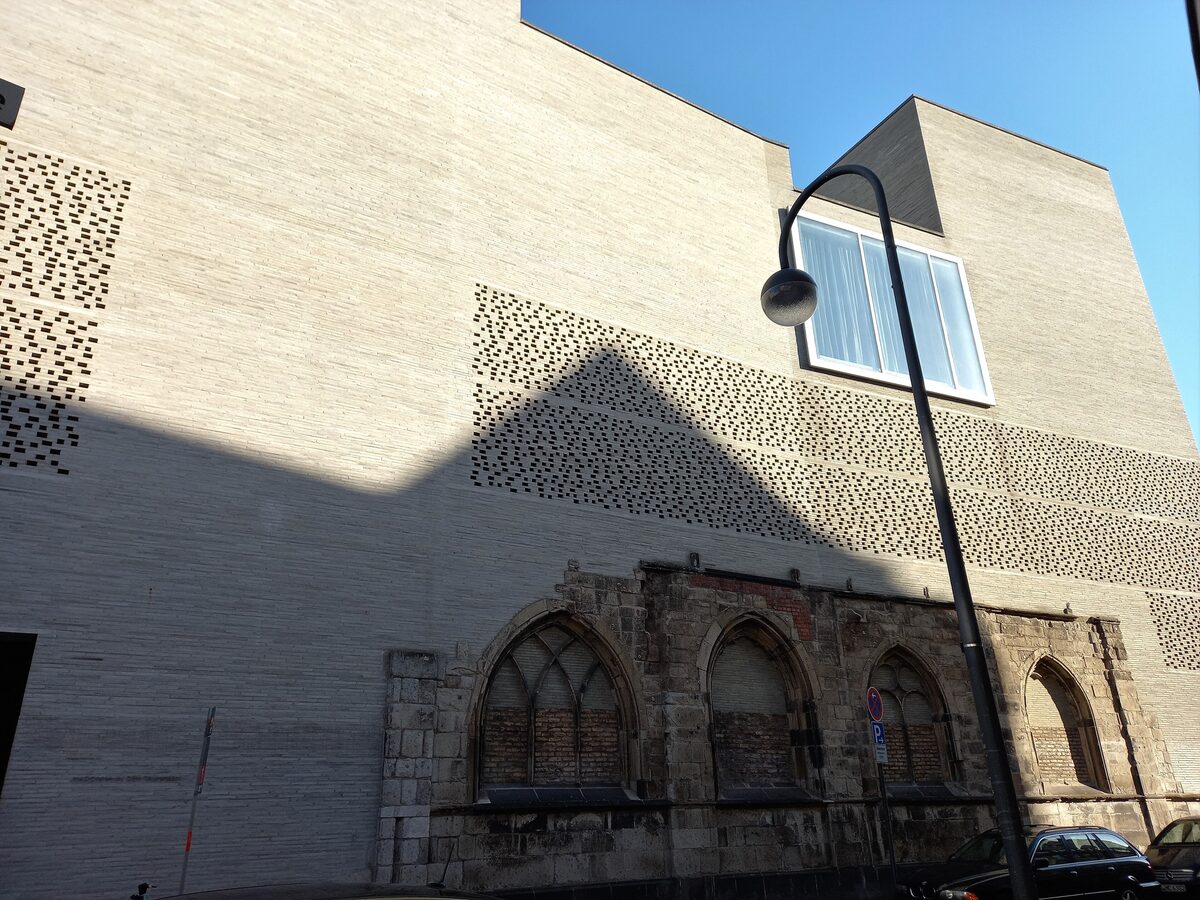 The gray brick wall of Kolumba, with its perforated pattern, rising over the ruins of the Gothic church of St. Kolumba