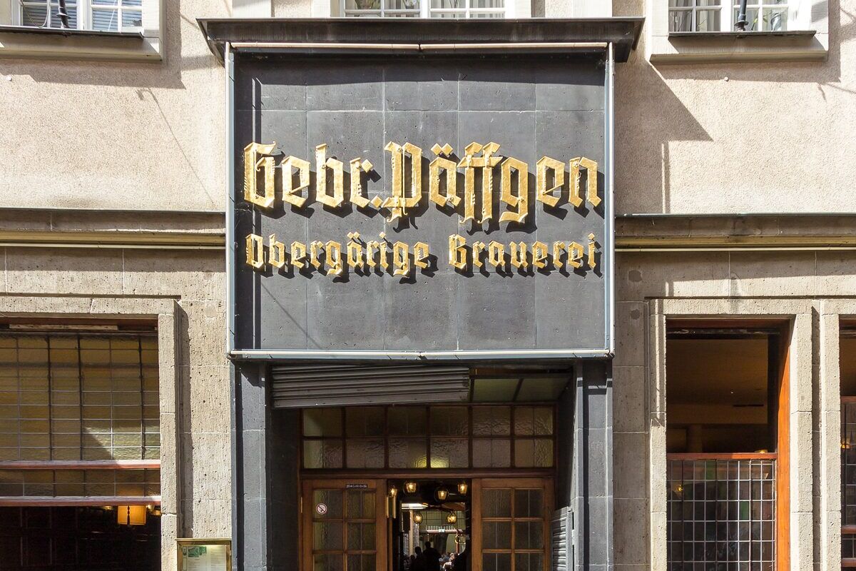 The gold lettering of the Gebr. Päffgen brewery sign above the brewhouse entrance on Friesenstraße