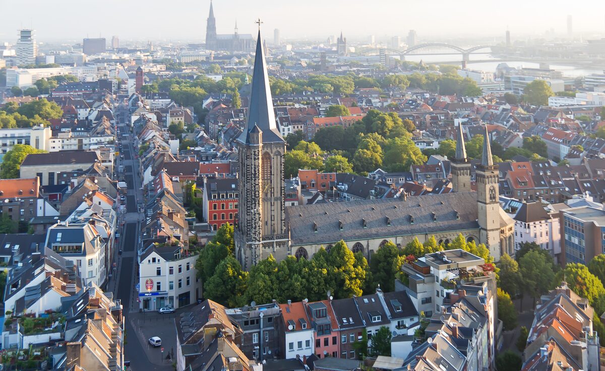 Aerial view of the tall tower of St. Severin and the Severinstraße with the cathedral on the horizon