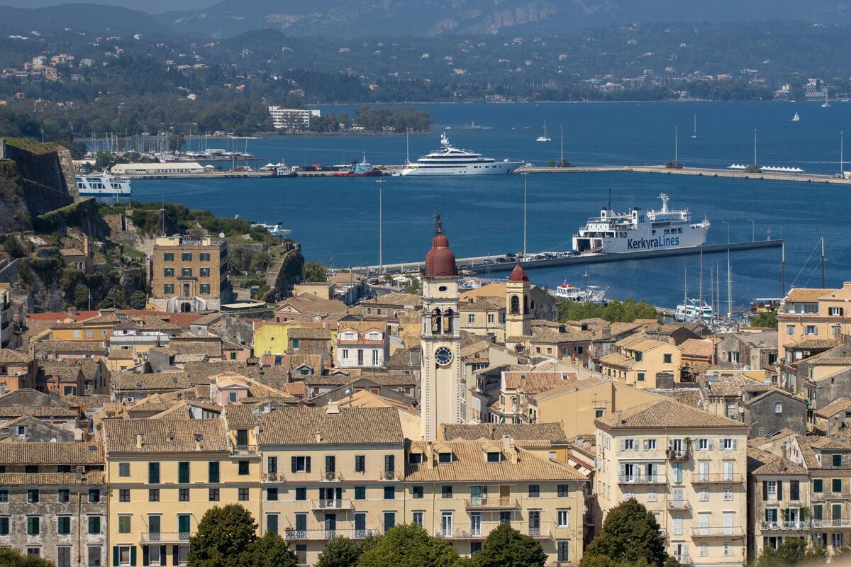 View from the New Fortress over the old town rooftops and the red-domed bell tower of St. Spyridon to the harbor, the Old Fortress and the bay