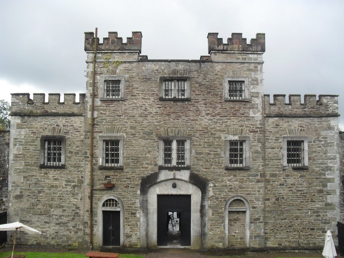 The castle-like gray stone front of Cork City Gaol, with battlements and an arched entrance