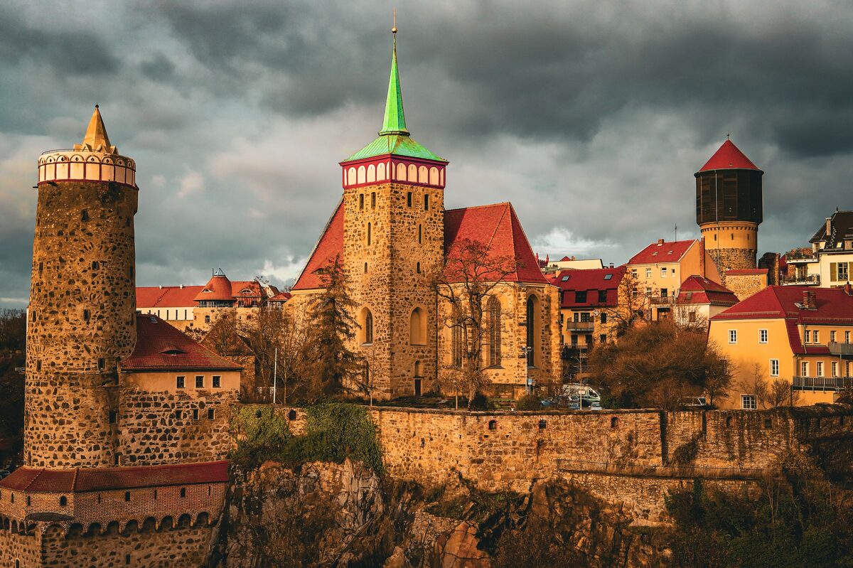 Bautzen's old town on its rock above the Spree, with the Alte Wasserkunst tower and church spires under dark clouds