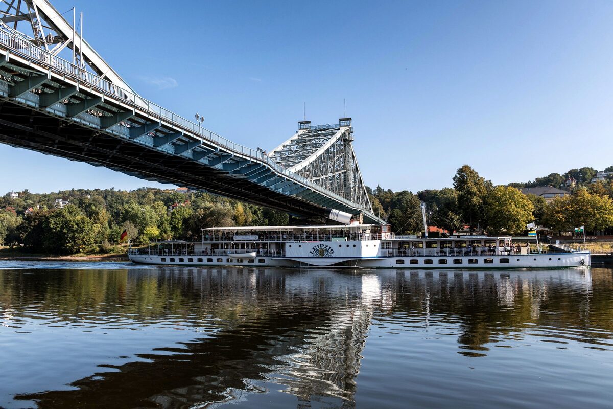 The steel Blaues Wunder bridge over the Elbe with a historic paddle steamer passing beneath it