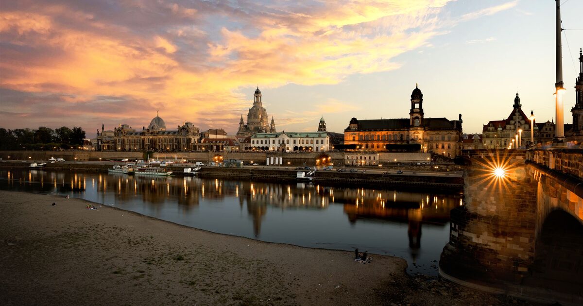 Sunset over the Dresden skyline from the Neustadt bank, with the Frauenkirche dome, the Hofkirche tower and the Augustus Bridge reflected in the Elbe