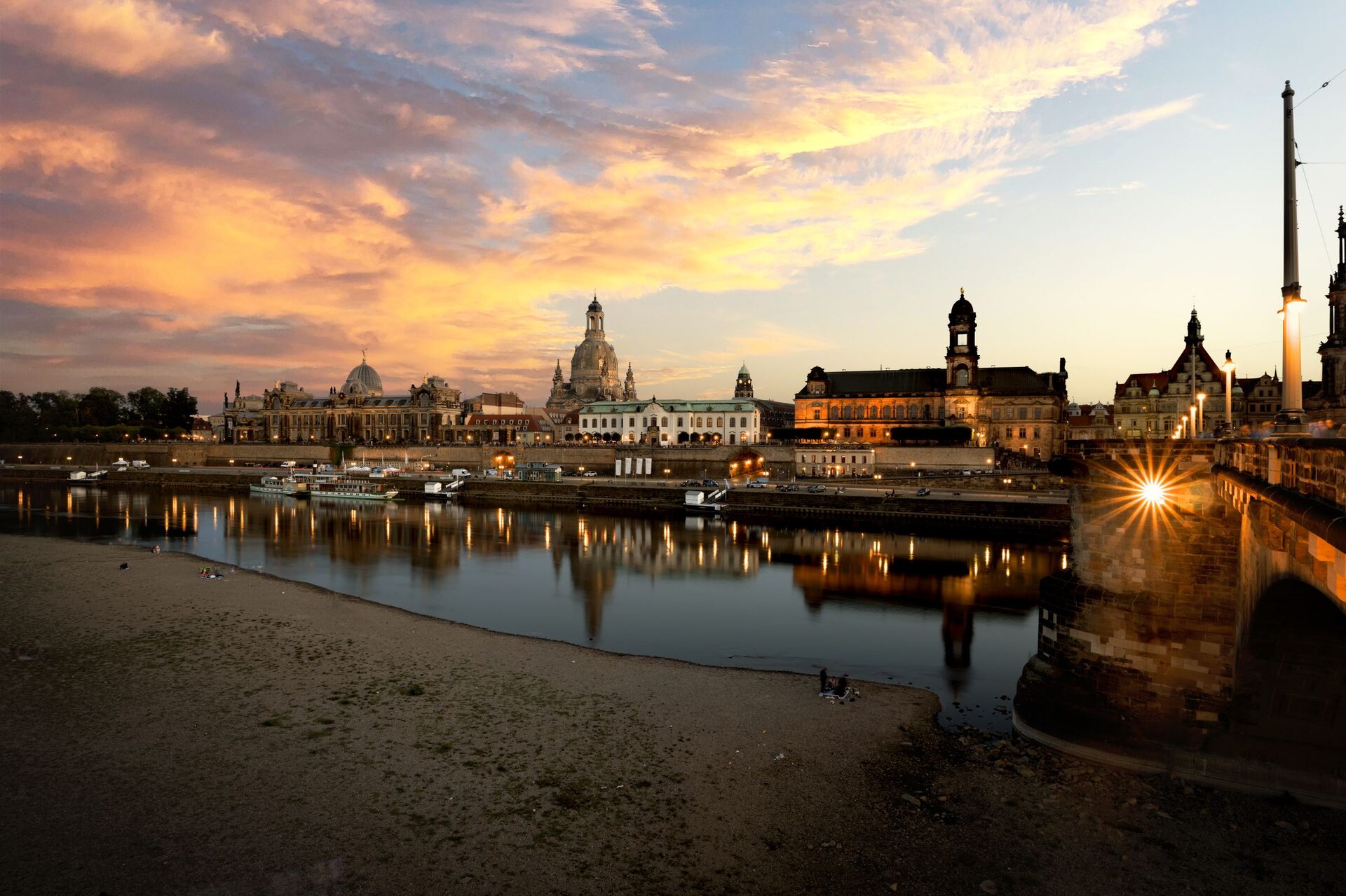 Sunset over the Dresden skyline from the Neustadt bank, with the Frauenkirche dome, the Hofkirche tower and the Augustus Bridge reflected in the Elbe