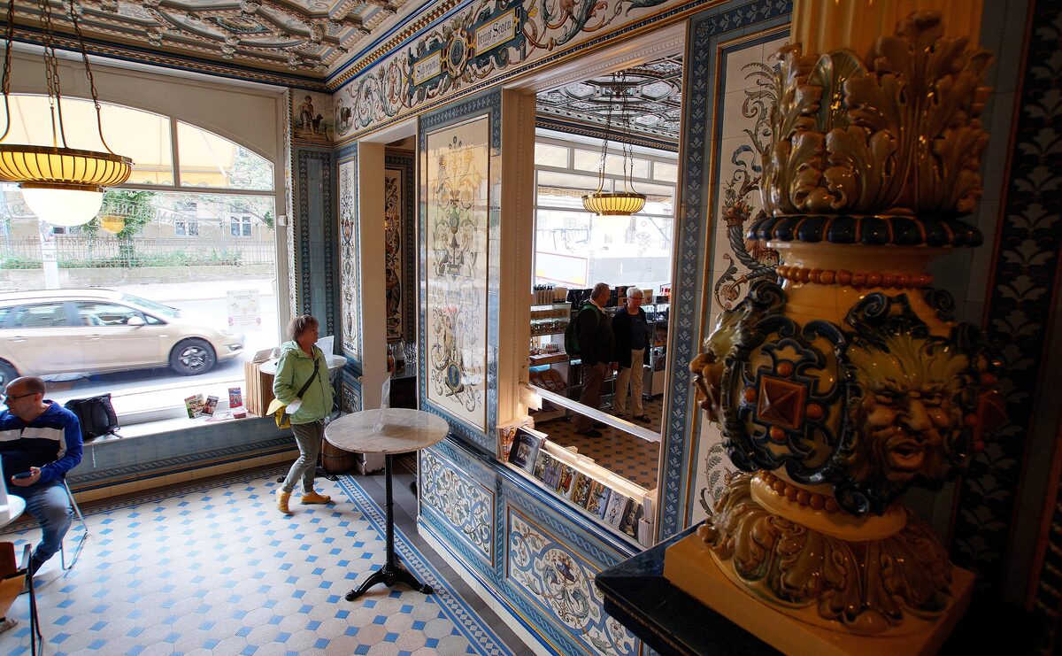 The shop of Pfunds Molkerei, its walls and ceiling covered in hand-painted Villeroy and Boch tiles, with customers at small tables