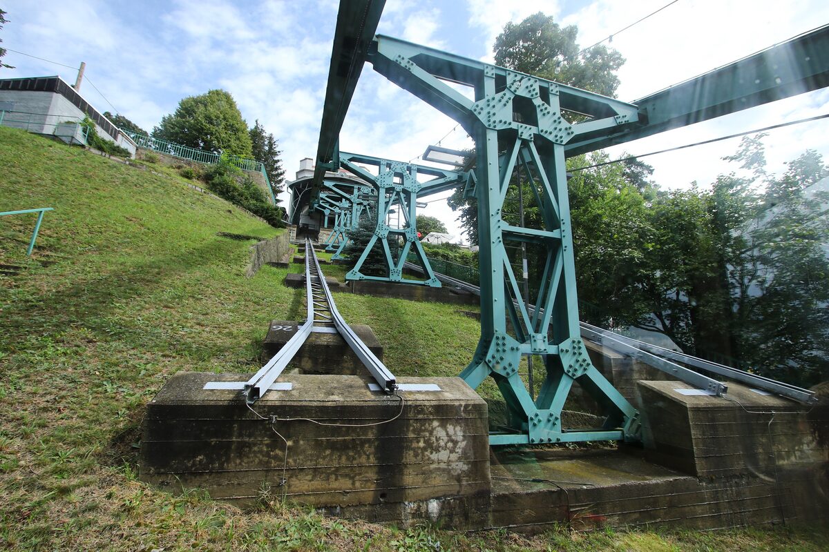 The green steel supports and rail of the Dresden Schwebebahn suspension railway on its hillside