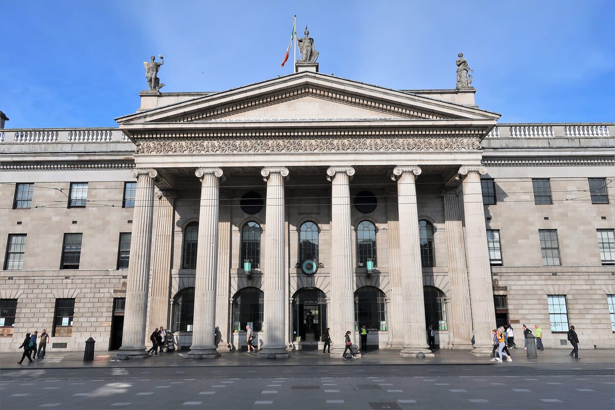 The columned portico of the General Post Office on O'Connell Street, with statues on the roof and the Irish flag flying above
