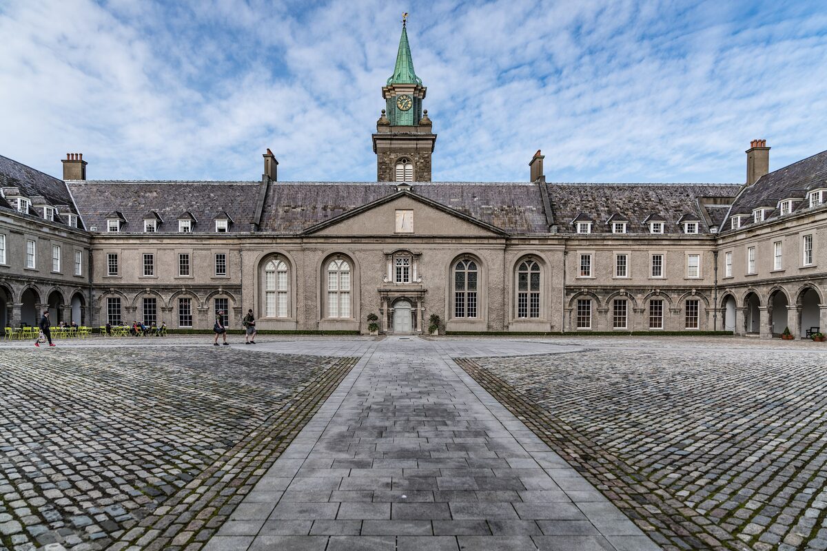 The arcaded courtyard of the Royal Hospital Kilmainham, with a clock tower and spire above the central entrance and a cobbled square in front