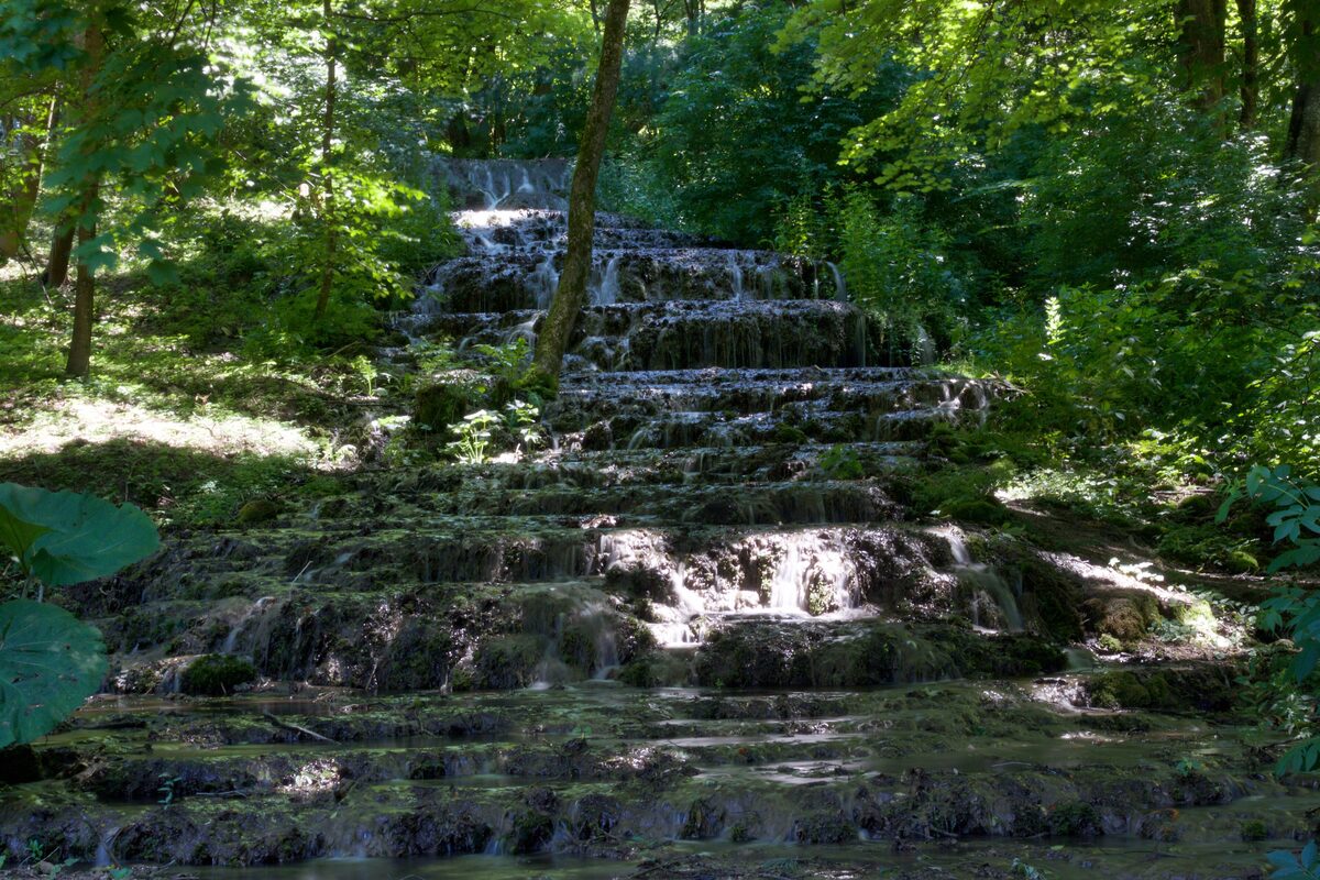 The Fátyol waterfall spilling down mossy steps in the shade of a beech forest in the Szalajka valley