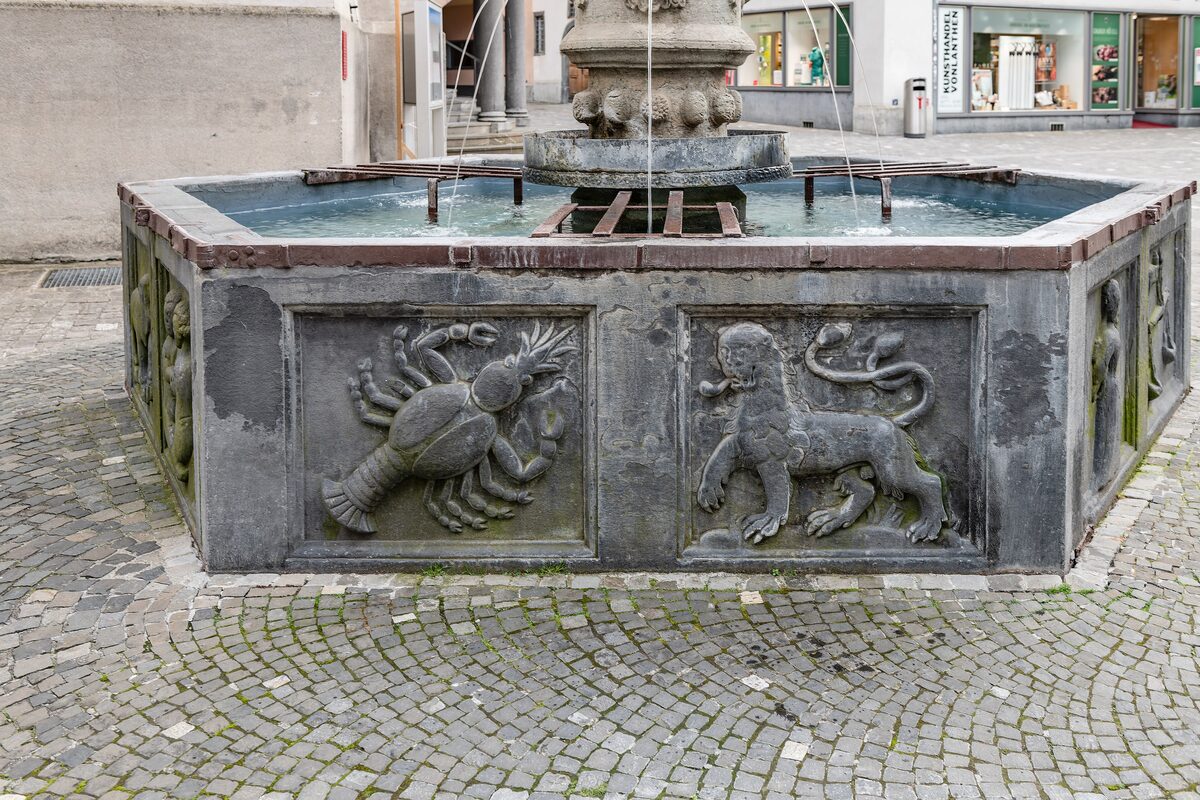 The Martinsbrunnen fountain on St. Martin's square in Chur, with carved lobster and lion panels