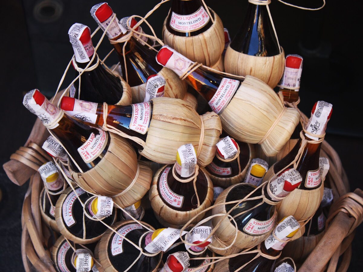 Old-fashioned straw-covered flasks of Chianti wine piled in a basket