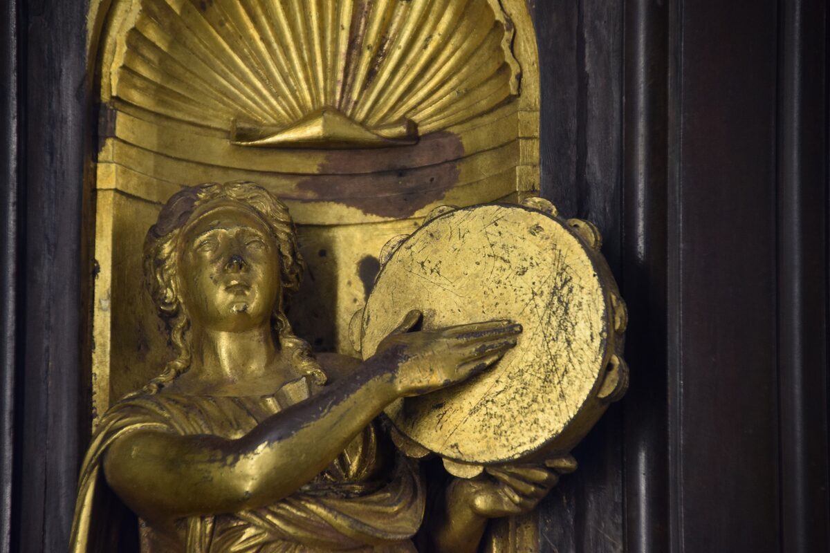 Close-up of a gilded bronze figure and relief from Ghiberti's Gates of Paradise in the Museo dell'Opera del Duomo