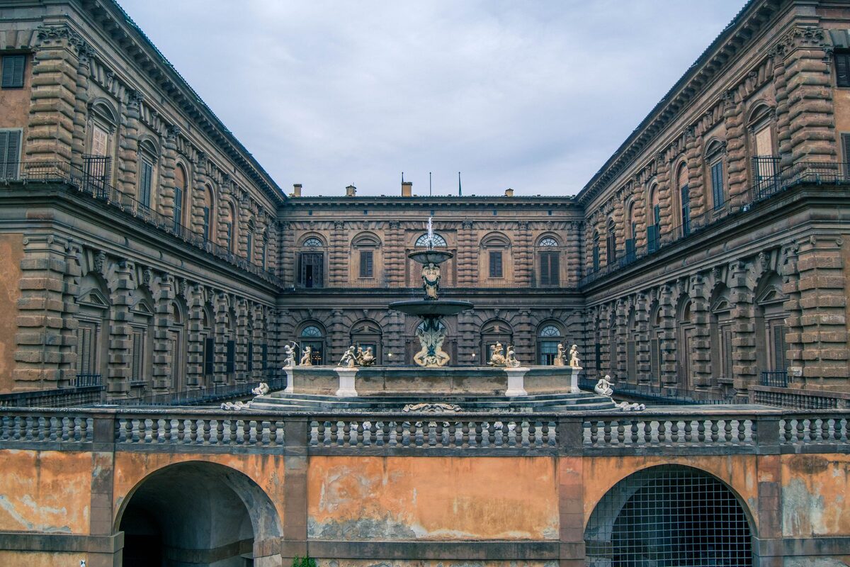 The inner courtyard of Palazzo Pitti, with rough rusticated stone walls on three sides and a terrace and fountain at the far end