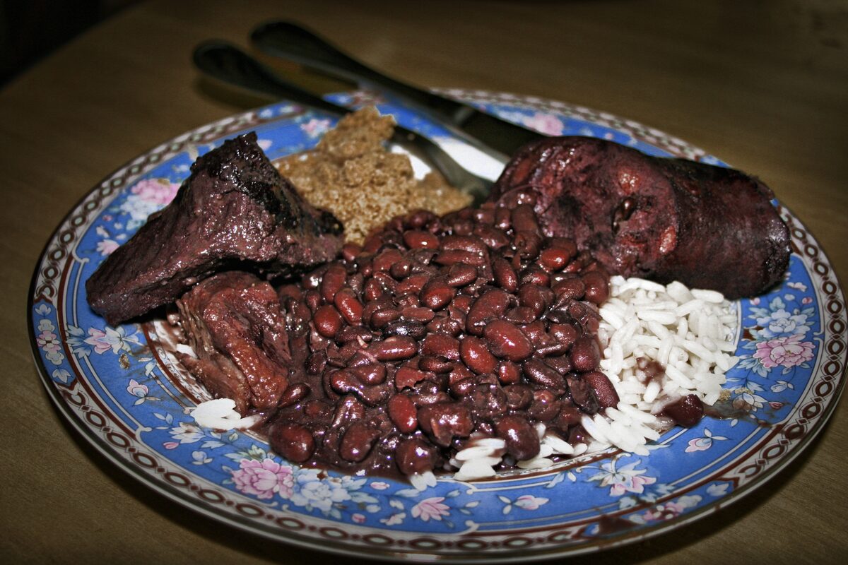 Feijoada on a blue plate: black beans with pork cuts and white rice