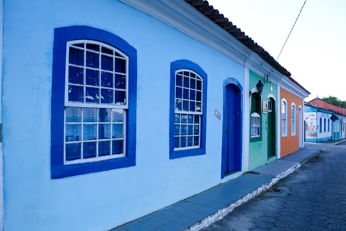 Colourful colonial houses in blue, green and orange along a street in Ribeirão da Ilha