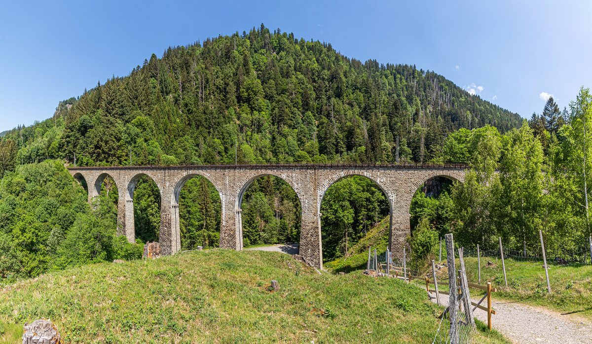The stone arches of the Ravenna viaduct in front of a forested hill in the Black Forest