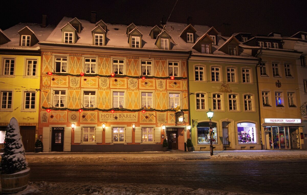 The painted facade of the Hotel Zum Roten Bären on Oberlinden, lit up at night