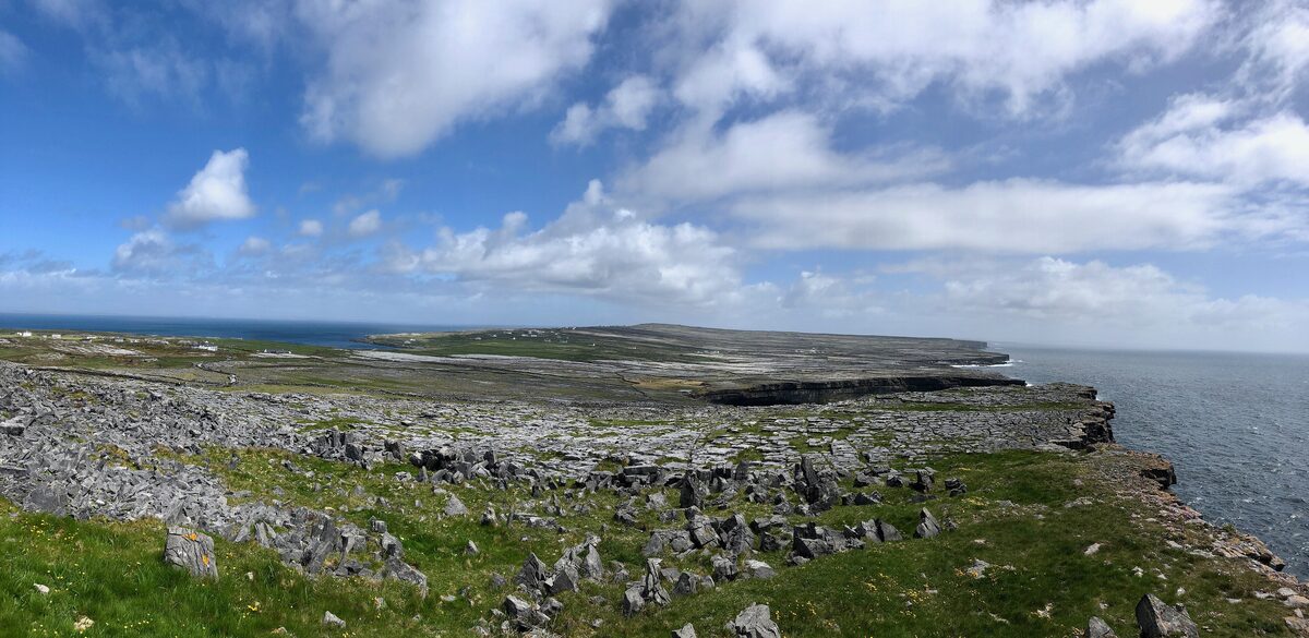 The limestone cliffs of Inis Mór near Dún Aonghasa, with gray rock and green grass running to the edge above the Atlantic