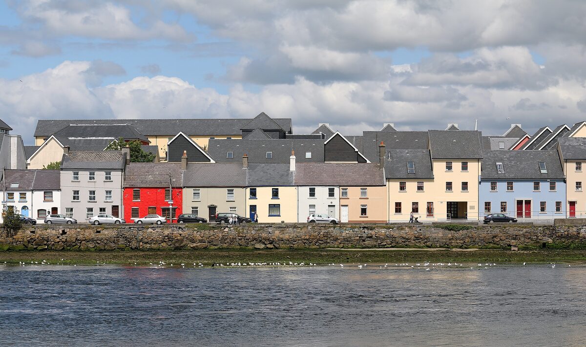 The Long Walk in Galway, a row of white, red, yellow and gray painted houses along the quay across the River Corrib