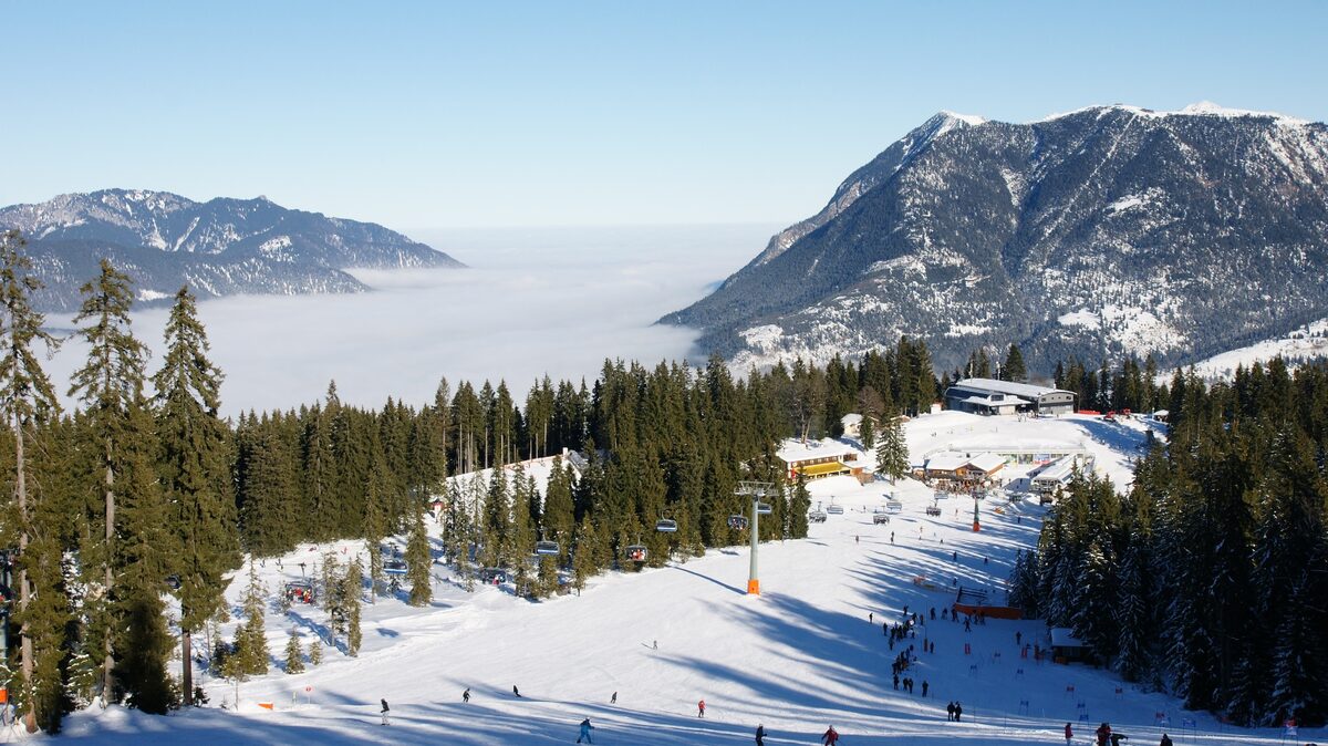 Snowy ski runs and a chairlift on the Hausberg above Garmisch, with forest and the Wetterstein peaks behind
