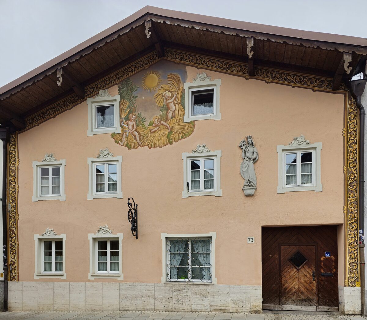 A house front with painted frescoes and a wooden gable on Ludwigstraße in Partenkirchen