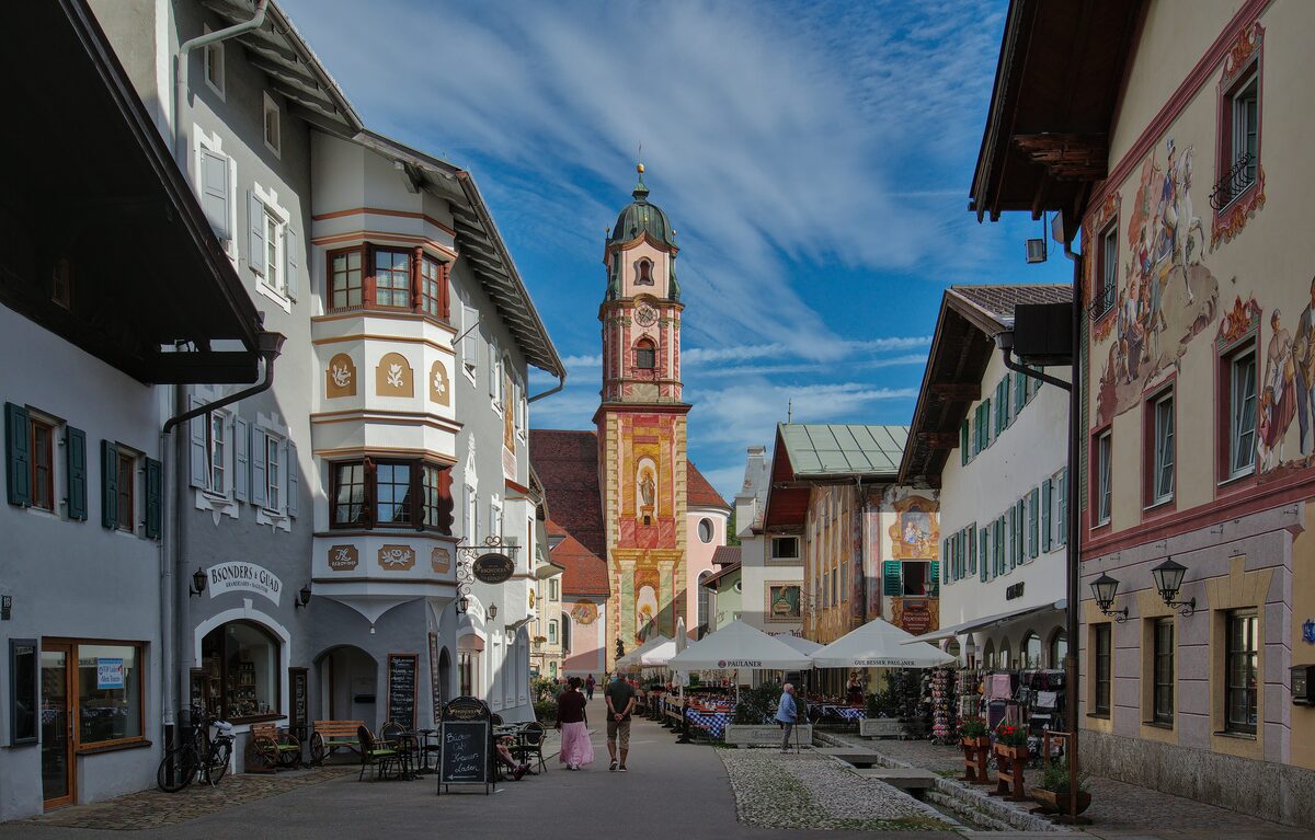 The painted Obermarkt of Mittenwald with the parish church tower rising above the houses
