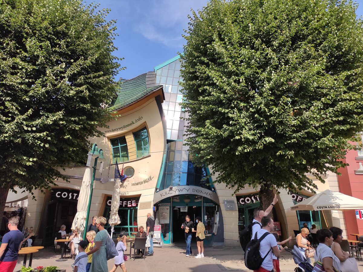 The Crooked House on Monte Cassino Street in Sopot, with its bent facade between two trees