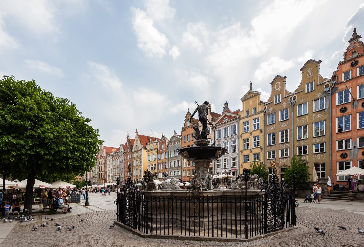 The Neptune Fountain on Długi Targ, with tall gabled merchant houses behind it