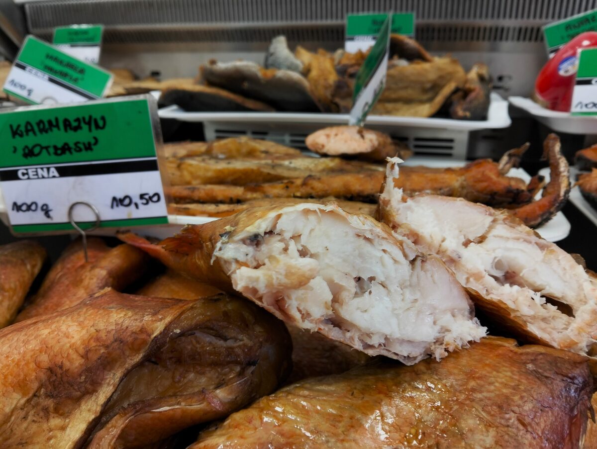 Whole smoked fish on a counter with price labels in a Polish fish shop
