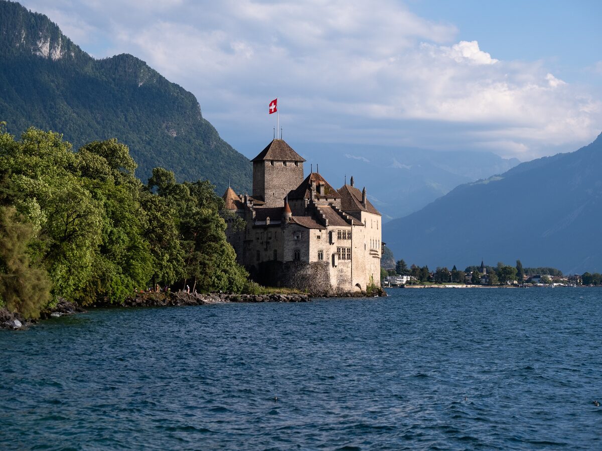 Château de Chillon on its rock at the edge of Lake Geneva, with mountains rising behind