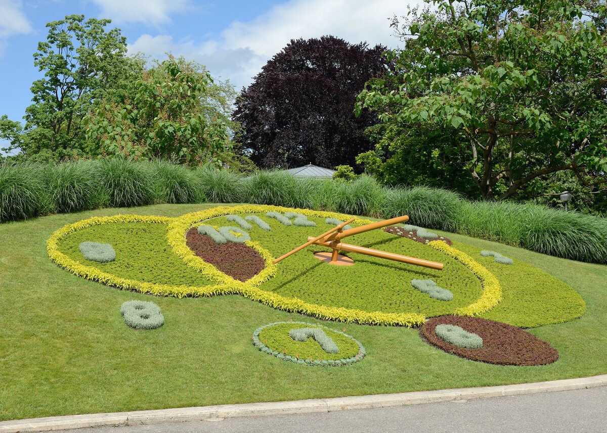 The Flower Clock in the English Garden, its clock face and hands set in a bed of yellow and green plants